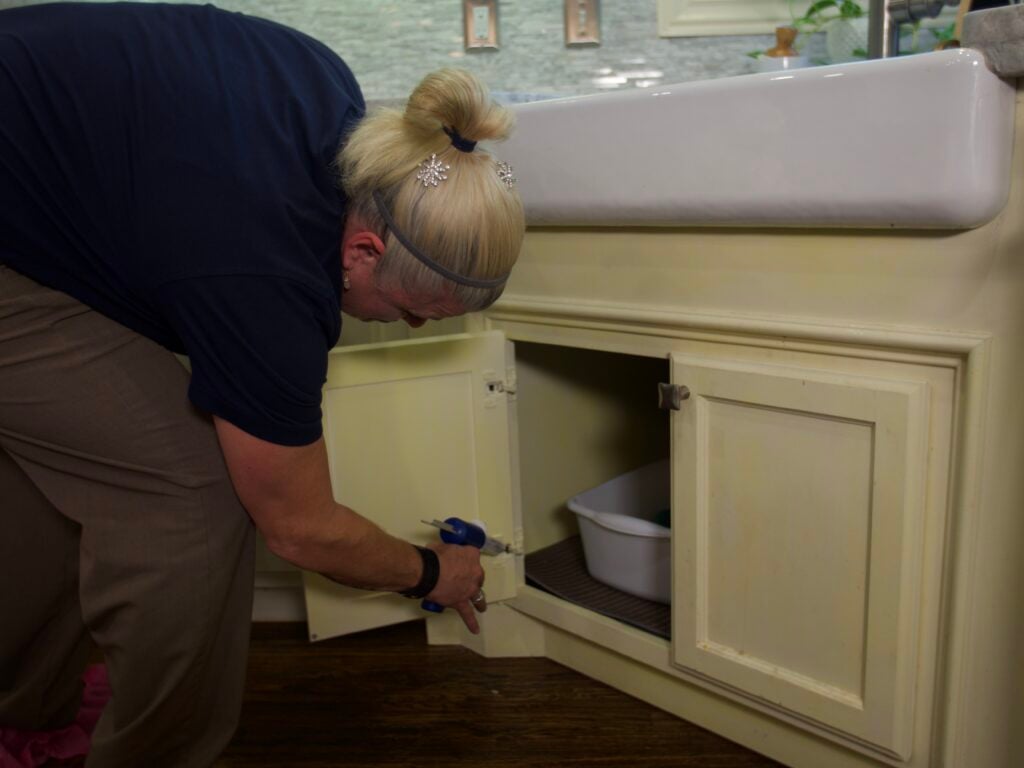Montgomery Exterminating technician inspecting under a kitchen sink